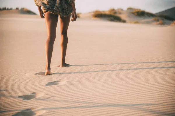 Gambe di una giovane donna nera che cammina nella sabbia in una duna deserta — Foto Stock