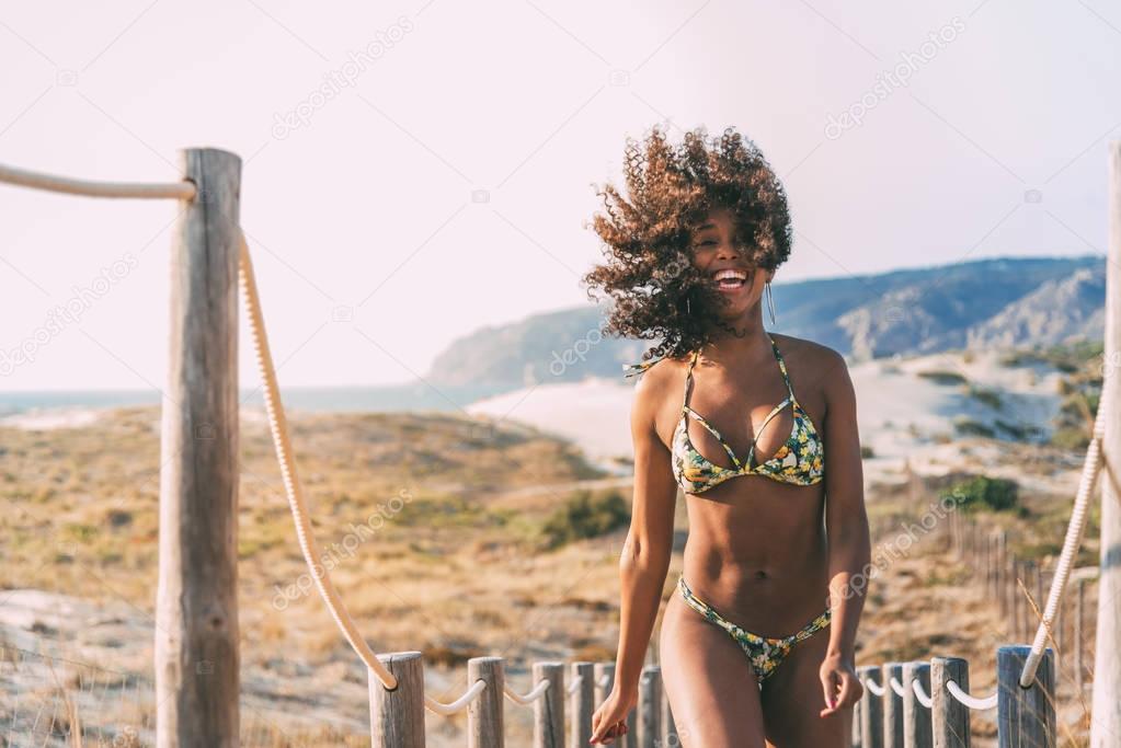 Beautiful young woman wearing a bikini in a wooden foot bridge a
