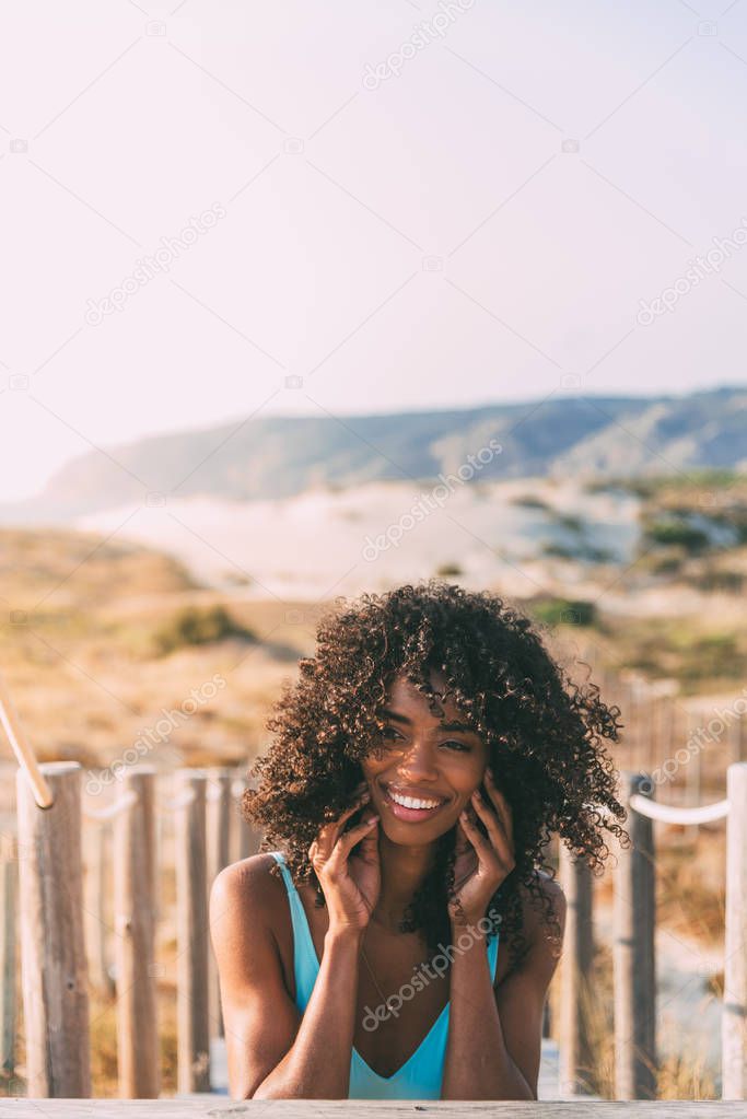 Beautiful young black woman lying down in a  wooden foot bridge 