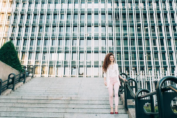 Young redhead business woman walking on the stairs