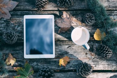 Kahve ve çam ağaçları açık ahşap bir masa üzerinde tablet