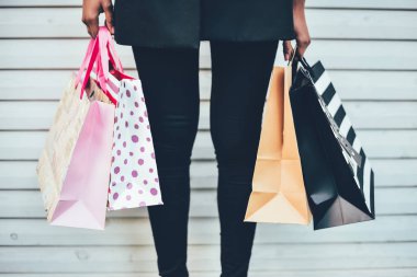 Kadın bacakları ile renkli alışveriş torbaları