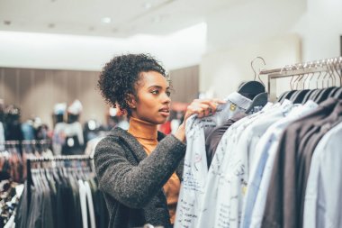Bir mağazada alışveriş yaparken siyah genç kadın