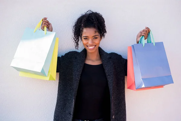 Gelukkig Jonge Zwarte Vrouw Met Boodschappentassen Tegen Een Witte Muur — Stockfoto
