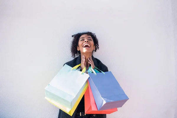 Jovem Mulher Negra Feliz Com Sacos Compras Contra Uma Parede — Fotografia de Stock