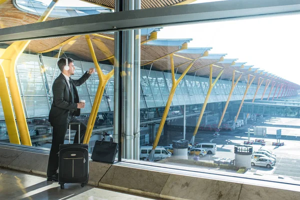 Junger Geschäftsmann Schaut Aus Dem Fenster Und Hört Musik Auf — Stockfoto