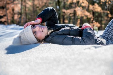 Genç sevimli kadın yalancı oynama ve kışın kar keyfi