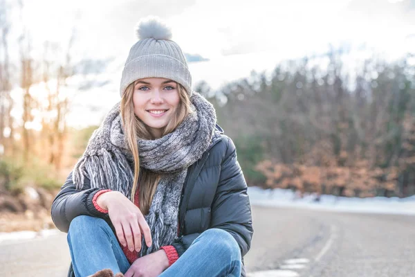 Jeune jolie femme sur une route enneigée en hiver — Photo