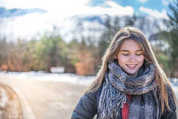 Молодая красивая женщина на дороге со снегом зимой — стоковое фото