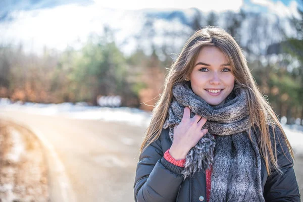 Young pretty woman on a road with snow in winter — Stock Photo, Image