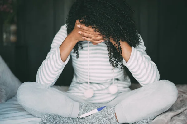 Átgondolt aggódik, és szomorú, fekete nő, a terhességi teszt az ágyban — Stock Fotó