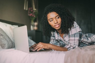 güzel siyah kadın yatakta dizüstü bilgisayar ve kahve
