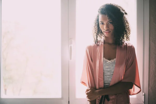 pretty black woman standing at the window