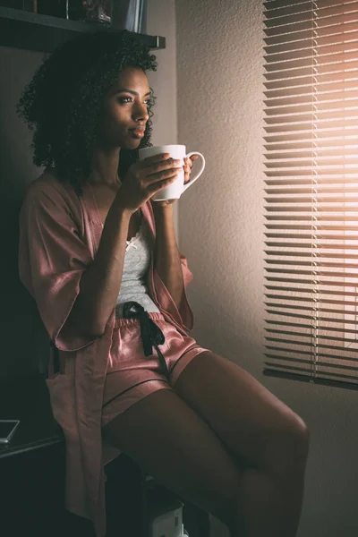 Pretty black woman sitting at the window with cup of coffee — Stock Photo, Image