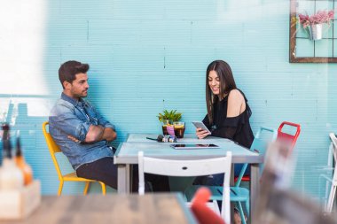 Mutlu genç çift oturma bir restoranda bir akıllı telefon ile