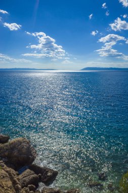 Sıcak güneşli yaz gün mavi gökyüzü ve okyanus. Ufuk ve beyaz bulutlar dağlar. Hırvatistan Avrupa'nın Adriyatik Denizi. Güzel ve rahatlatıcı fotoğraf güzel renkler ile.