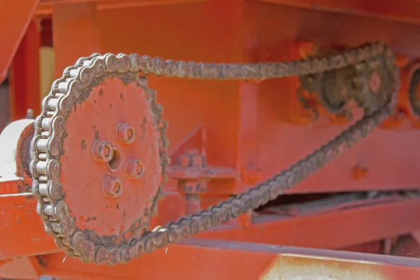 Chains and gear wheels in agricultural machinery and  orange bac