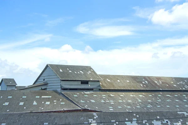 Dachu starego magazynu w błękitne niebo. — Zdjęcie stockowe