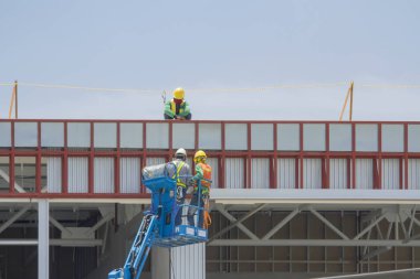 İşçilerin bir sepet içinde bir fabrika inşa sayfasında, yüklemekte olduğunuz.
