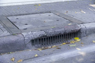 Su drenaj yol ve düşen yapraklar üzerinde eski