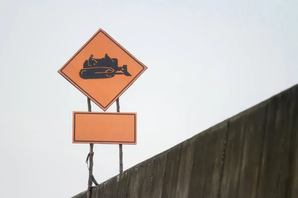 Schild für Arbeitsschlepper schwarzes Symbol orange Hintergrund — Stockfoto