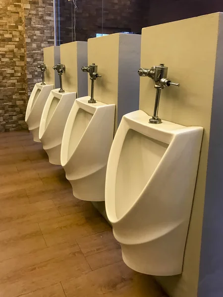 Urinarios de hombres blancos forrados en un inodoro — Foto de Stock