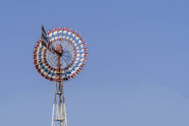 Rüzgar Türbini rengi kırmızı, beyaz, mavi ve mavi gökyüzü ile eski.