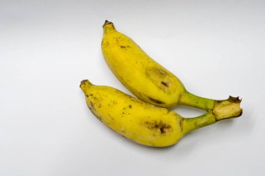 Beyaz bir arka plan üzerinde iki muz olgunlaştı.
