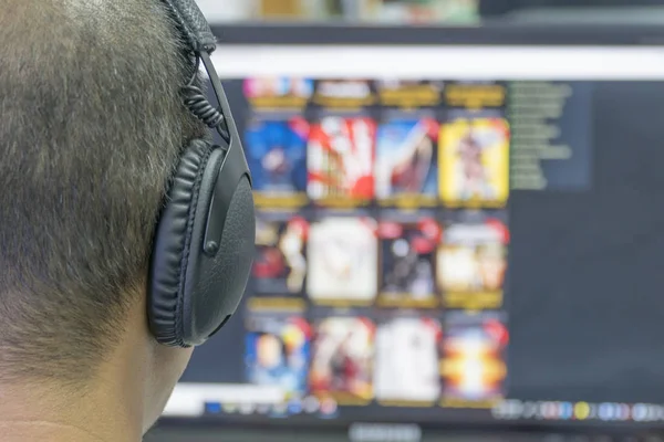 Men wear headphones on the computer screen.
