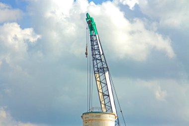Mavi gökyüzünde turna taşı yeşili çalışıyor.