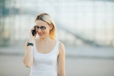 Şık iş kadını telefonda konuşurken gözlük