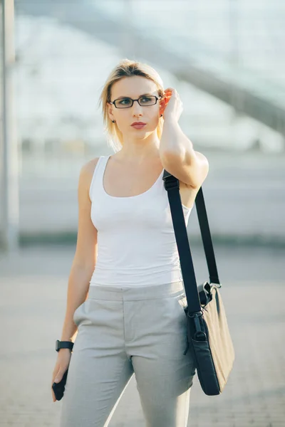 Geschäftsfrau mit Telefon und Uhr vor dem Gebäude — Stockfoto