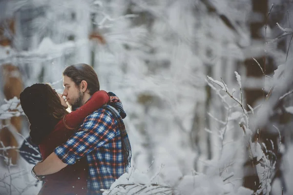 Pareja joven enamorada besándose en bosque frío — Foto de Stock