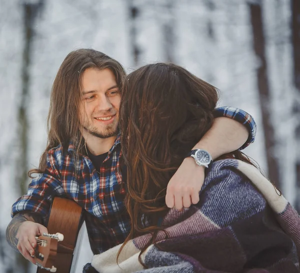 남자 겨울 숲에서 그의 여자 친구에 게 기타를 재생 — 스톡 사진