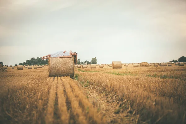 Beautiful Girl on Hay Bales in the Fields