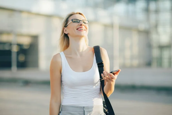 Blonde Geschäftsfrau liest eine Nachricht am Telefon — Stockfoto