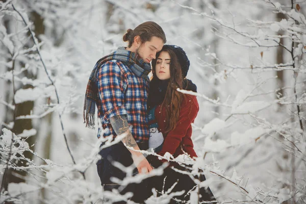 Casal abraçando uns aos outros na floresta de inverno — Fotografia de Stock