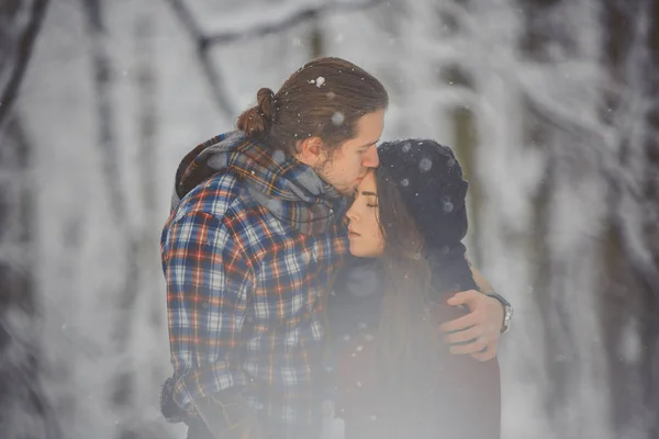 Felice coppia amorevole passeggiando nella foresta innevata — Foto Stock