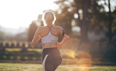 Güneşli sabah sırasında park üzerinde çalışan kadın