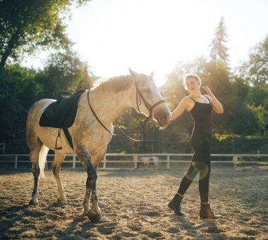 güzel bir genç kadın açık bir atı ile