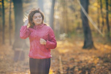Genç kadın bir orman yolu üzerinde gündoğumu sırasında çalışan