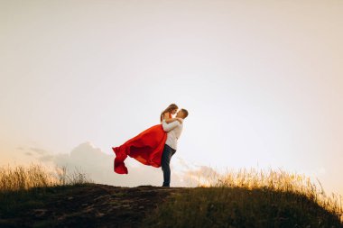 Çiftler Buluşması, Sarılma ve Öpüşme. Güzel romantik erkek ve kadın gün batımında kucaklaşıp öpüşürler.
