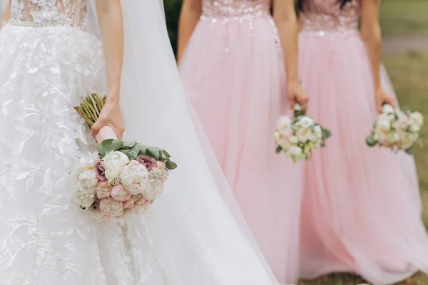 Noiva com damas de honra ao ar livre no casamento. Fila de damas de honra com buquês na cerimônia de casamento . — Fotografia de Stock