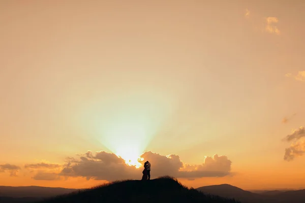 Casal jovem beijos envolvidos em preliminares tocando uns aos outros. casal feliz fica em abraço e beijos uns aos outros no pôr do sol bonito — Fotografia de Stock