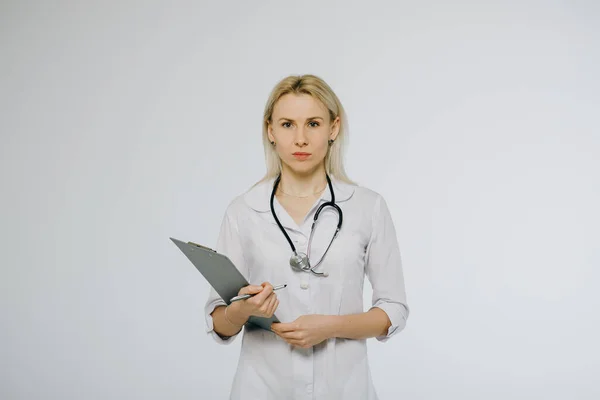 Asiático mulher médico em casaco branco e estetoscópio segurando prancheta isolada sobre fundo branco — Fotografia de Stock