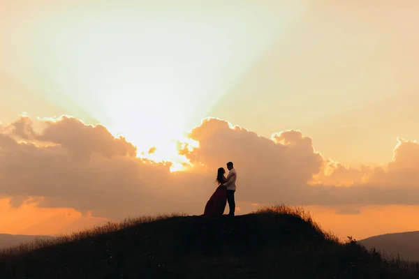 Η σιλουέτα ενός ερωτευμένου ζευγαριού στο ηλιοβασίλεμα, αγκαλιάζουν το φιλί και κοιτάζονται με τρυφερότητα. Αργή κίνηση. Νεαρό ζευγάρι το ηλιοβασίλεμα. — Φωτογραφία Αρχείου