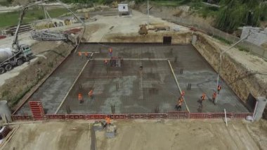 İnşaatçılar beton döktü. Büyük bir inşaat alanının temelinde inşaatçılar bir gökdelen ya da fabrika inşa ediyorlar. İnşaat alanında çalışan işçiler.
