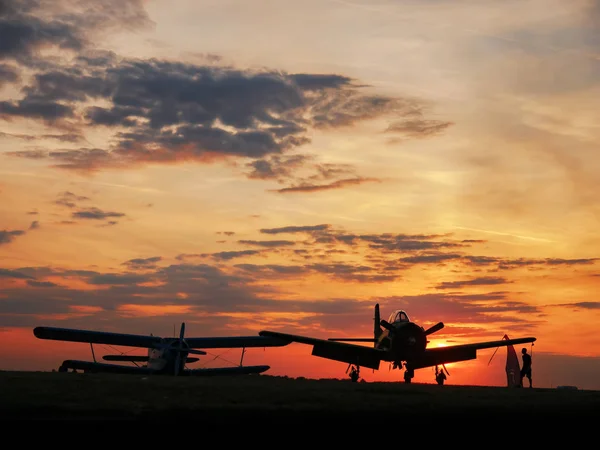 Vista sobre os aviões no aeroporto de Szeged com o pôr do sol em t — Fotografia de Stock