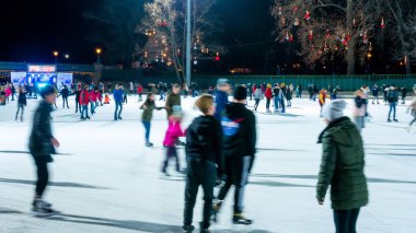 Şehir Parkı Buz Pisti 'nde buz pateni yapan insanları izliyoruz. 