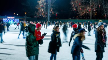 Şehir Parkı Buz Pisti 'nde buz pateni yapan insanları izliyoruz. 